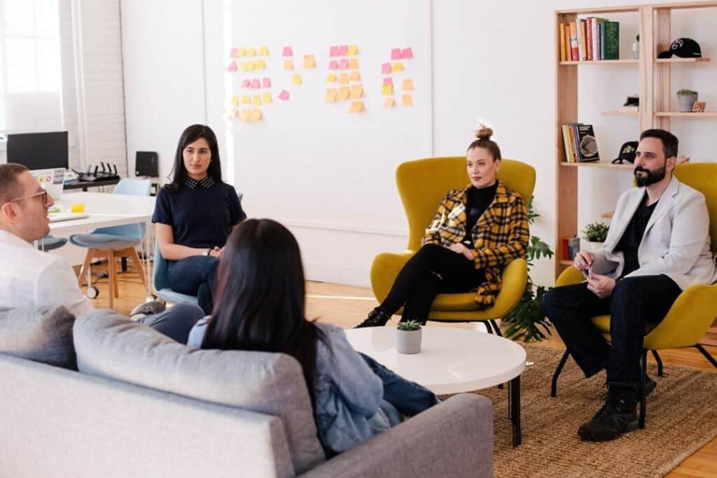 A group of people sitting at a table in a room

Description automatically generated