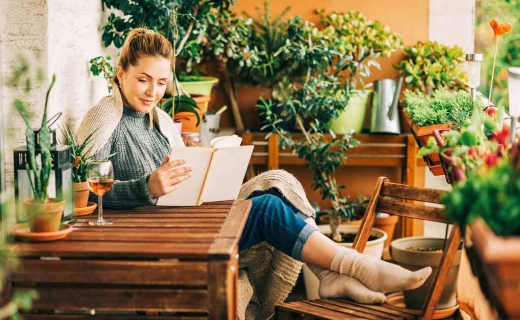 Young woman reading and surrounded by plants